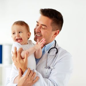 happy doctor or pediatrician with baby at clinic medicine, healtcare, pediatry and people concept - happy doctor or pediatrician holding baby on medical exam at clinic